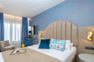 马拉加帕拉斯特艾尔莫斯酒店的一间卧室配有一张带蓝色墙壁的大床