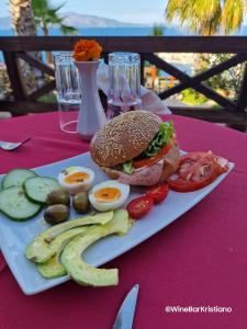 萨兰达Villa Kristiano 21的桌上放有三明治、鸡蛋和蔬菜的盘子
