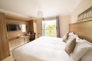 斯莱戈河畔酒店的卧室配有一张大白色床和电视。