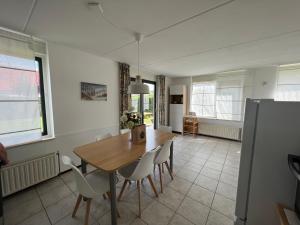 布雷斯肯斯Hello Zeeland - Vakantiehuis Stern 207的厨房以及带木桌和椅子的用餐室。