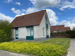 布雷斯肯斯Hello Zeeland - Vakantiehuis Stern 207的白色房子,有棕色的屋顶