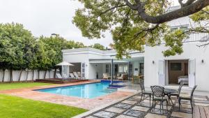 斯泰伦博斯Villa Stellenbosch的一个带游泳池和房子的后院