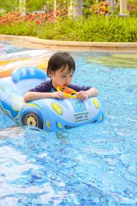 三亚三亚海棠湾喜来登度假酒店（丰富儿童玩乐+S秀表演）的一个男孩在游泳池里充气地骑着