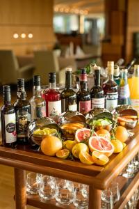 措伊伦罗达赛兰罗大比奥斯酒店的一张桌子上放着许多瓶装葡萄酒和水果