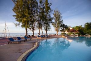 七岩查安欧亚兰宫酒店的一个带椅子的游泳池,背景是大海