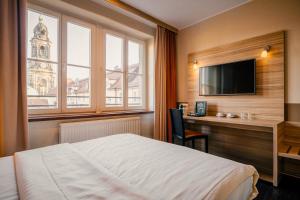 德累斯顿Star G Hotel Premium Dresden Altmarkt的酒店客房配有一张床、一张书桌和一台电视。