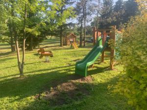 KrompachChalupa Krompach的公园内一个带绿色滑梯的游乐场