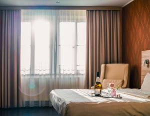 德累斯顿Star G Hotel Premium Dresden Altmarkt的酒店客房,配有一张床和一瓶啤酒