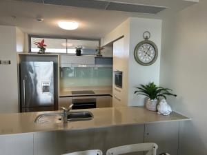 卡伦德拉Exclusive Apartment with Ocean Views的厨房配有水槽和墙上的时钟