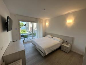 多马索Resort le Vele Suites and Apartments的一间卧室配有一张床,阳台配有桌子