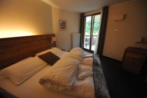 Bedollo布鲁萨格维塔生态酒店及健身中心的一间卧室配有两张带毯子的床和窗户。