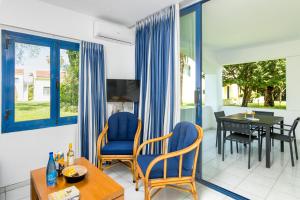 古维亚Helion Resort的客厅配有蓝色的椅子和桌子
