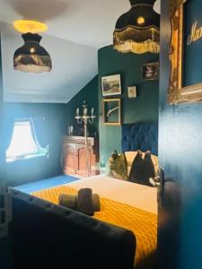 伊尔克利The Gin Lounge Rooms的一间卧室配有一张带黄色床单和蓝色墙壁的床。