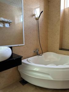 波来古市Bình Minh Motel的浴室配有白色浴缸和水槽