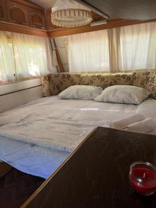 东吉托伊KAMP-PRIKOLICA的一张大床,位于带桌子的房间