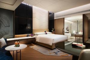 西安西安万丽酒店(近大唐不夜城)的一间卧室设有一张大床和一个大镜子