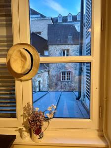 拉瓦勒Studio dans une grande maison médiévale au centre historique de Laval的窗户配有帽子,享有网球场的景致