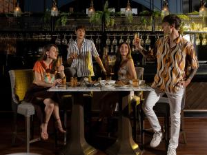曼谷SKYVIEW Hotel Bangkok - Sukhumvit的一群人坐在酒吧的桌子旁