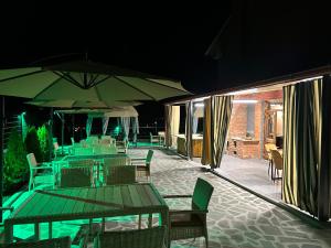 博尔若米Pesvebi Design Hotel and Cellar的露台在晚上配有桌椅和遮阳伞