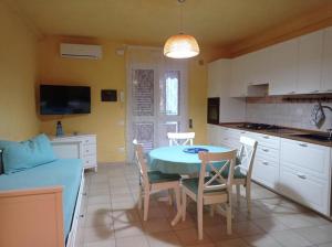 波利科罗Case Vacanza Villaggio Riva Azzurra的厨房以及带桌椅的用餐室。