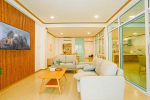 清刊Chiang Khan COZY Pool Villa的客厅配有白色家具和桌子