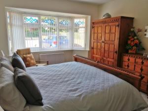 Leylands的一间卧室配有一张床、梳妆台和窗户。