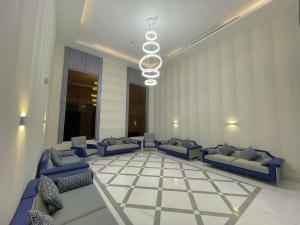 麦地那فندق بلينسية Balensia Hotel的大堂设有蓝色的沙发和一个棋盘地板