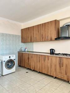 巴统BATUMI KEY 8的厨房配有木制橱柜和洗衣机。