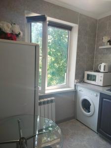 阿拉木图Квартира на Панфилова "Арбат" 1 комн的厨房配有洗衣机和窗户。