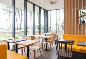 圣茹尔德马朗讷B&B HOTEL Saint-Geours-de-Maremne Hossegor的餐厅设有桌椅和窗户。