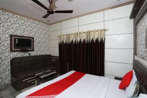 阿格拉OYO Hotel Vanshika的一间卧室配有一张床和一台平面电视