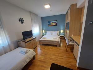 Srpski ItebejMotel MS的酒店客房设有两张床和电视。