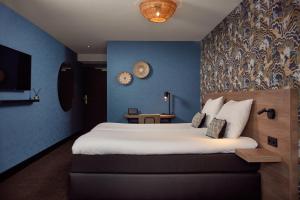 德科赫Van der Valk Texel - De Koog的一间卧室设有一张蓝色墙壁的大床