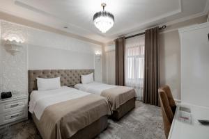 撒马尔罕Hotel Billuri Sitora的酒店客房设有两张床和窗户。