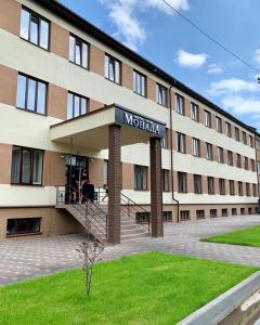 乌日霍罗德Monada Hotel & Hostel的一座大建筑,上面标有酒店标志