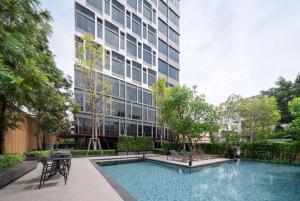 曼谷Ramada By Wyndham Bangkok Sukhumvit 87的一座高楼前的游泳池