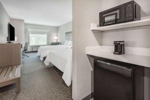 JacksonLa Quinta Inn & Suites by Wyndham Jackson-Cape Girardeau的酒店客房配有两张床和微波炉。