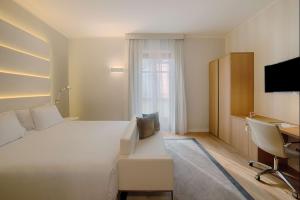 都灵NH Collection Torino Santo Stefano的酒店客房设有一张白色大床和一张书桌