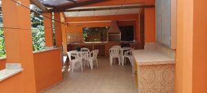 佩尼多Cantinho do Rio的户外庭院配有白色的椅子和桌子