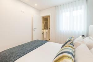 布拉加Art's Braga Apartment - Minho's Guest的一间白色卧室,配有床和一间浴室