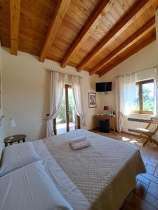 萨杜勒尼亚Casale Terre Rosse Garden的一间带一张大床的卧室,位于带窗户的房间内