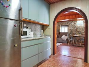 桑亨霍Casa d´Amado的带冰箱的厨房和客厅