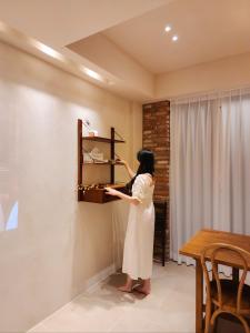 釜山Poolvilla Gaon的女人正在走进一个房间里的一个架子