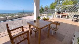 圣安吉罗山La veranda sul golfo的阳台的天井配有木桌和椅子