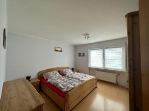 普莱滕贝格An der Glocke的一间卧室配有一张床、一张桌子和一个窗户。