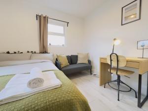 伦敦Leyton House - SleepyLodge的一间卧室配有一张床、一张桌子和一把椅子