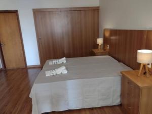 圣卡洛斯Chalet Rustico da Elena com Sauna y Jacuzzi Unicep的一间卧室配有一张床,上面有两条毛巾