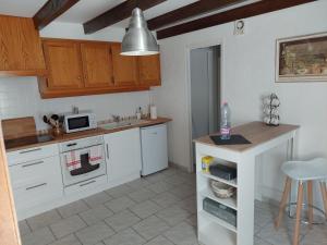 吕讷Le Cadran的厨房配有白色橱柜、水槽和桌子