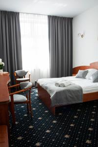 库亚维地区索莱茨Hotel Restauracja Autos的配有一张床和一把椅子的酒店客房