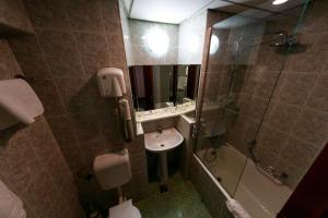 萨图马雷奥罗拉酒店的一间带水槽、淋浴和卫生间的浴室